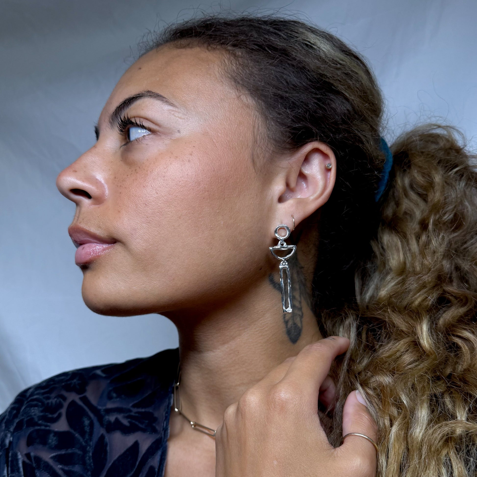 Close-up of a woman wearing a silver earring.