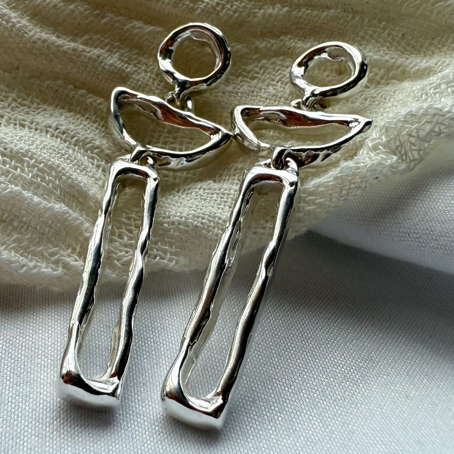 moon dancer earrings on a textured fabric background